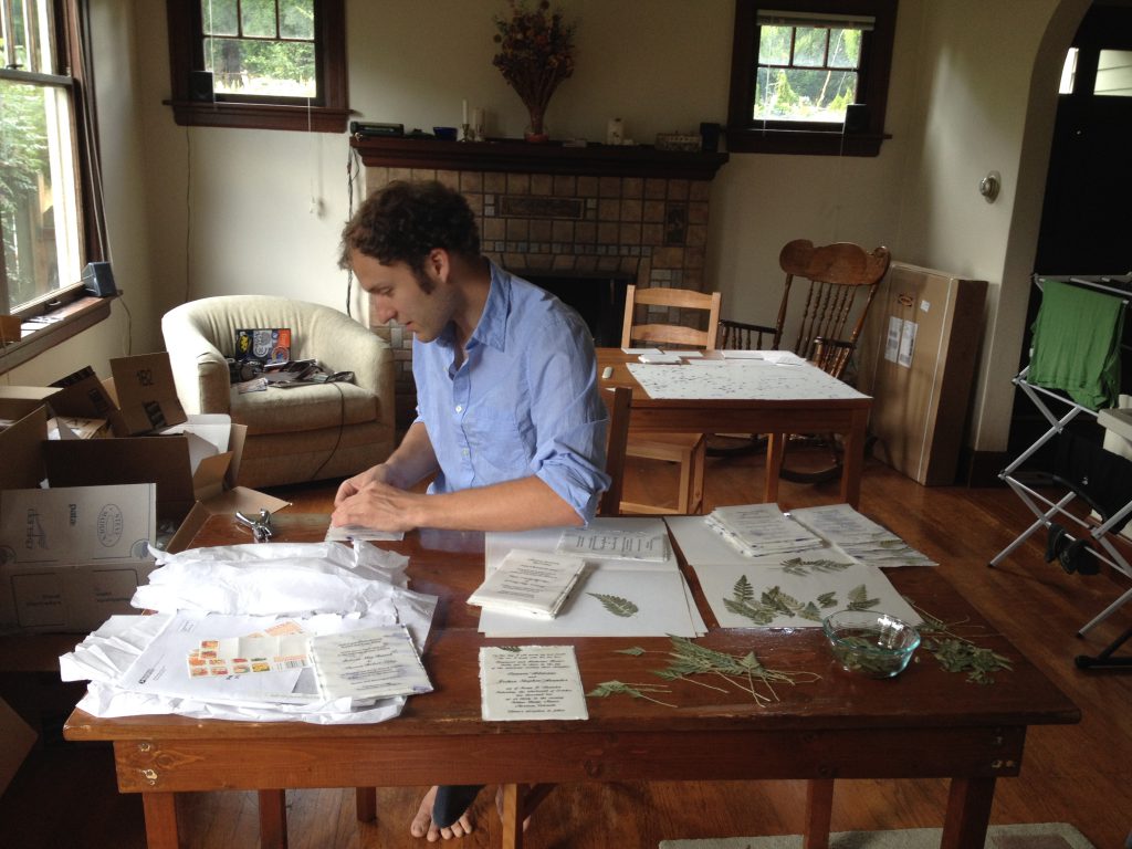 Seattle couple assembles Of The Earth invitations at home.