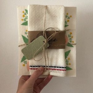 hand holding a jute wrapped dishtowel with a green gift tag