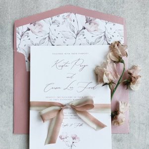 pink toned wedding invitation with sweet peas and ribbon